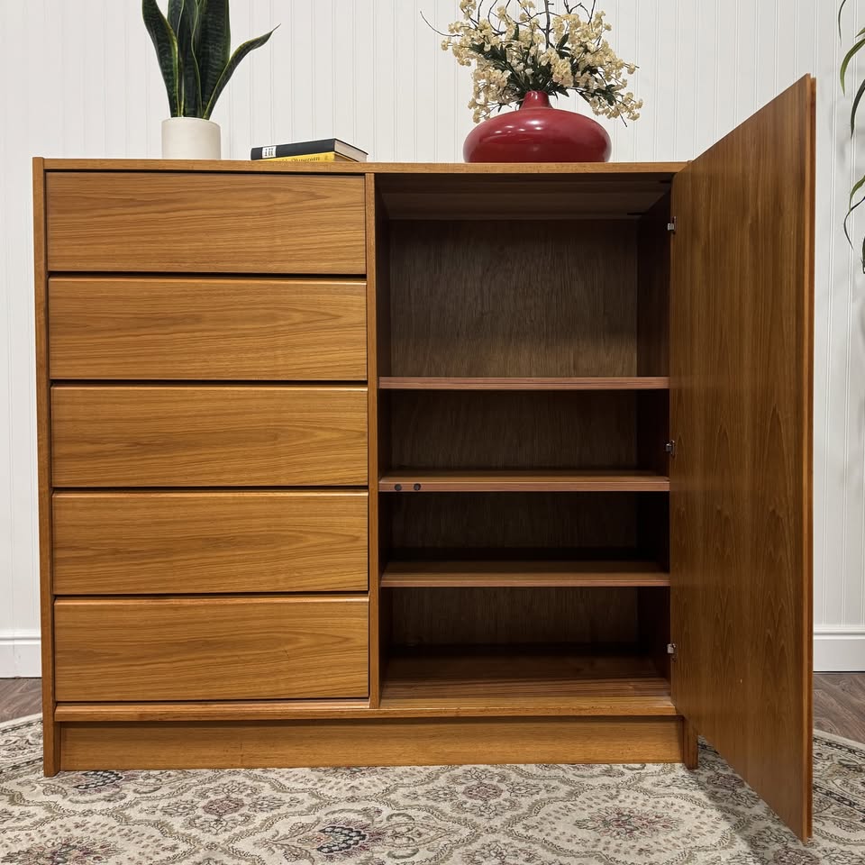 Tall teak dresser with drawers on left side. Door open showing shelves on right side.