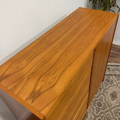 Close up view of the top of a Danish teak MCM dresser and cabinet, showing grain pattern