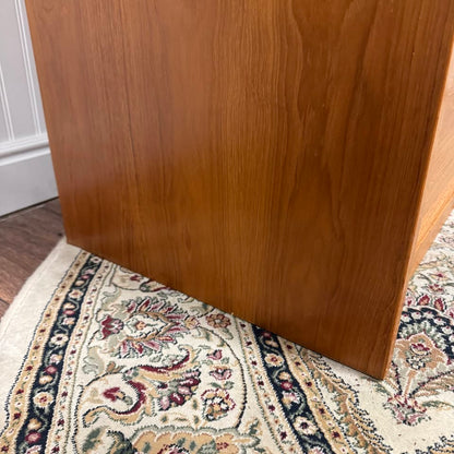 Close up view of bottom side edge of Danish teak MCM dresser and cabinet