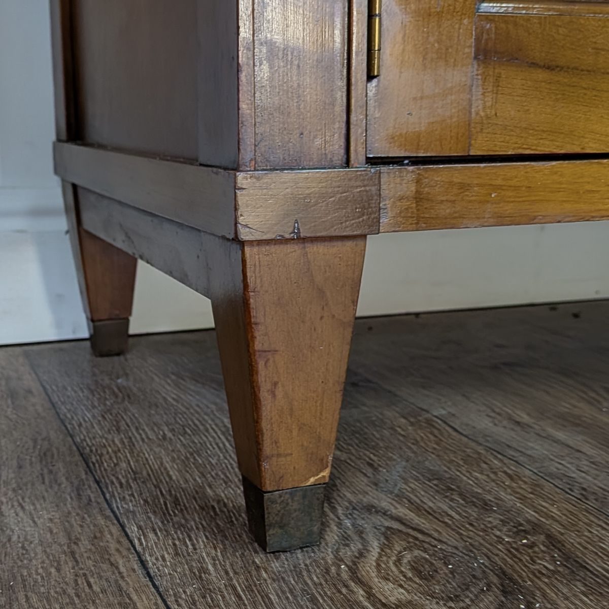 Signs of wear on front left leg of cabinet. 
